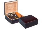 Two cherry wood humidors one is open showing a hygrometer, a double blade guillotine cutter, and a leather cigar case the other one is closed
